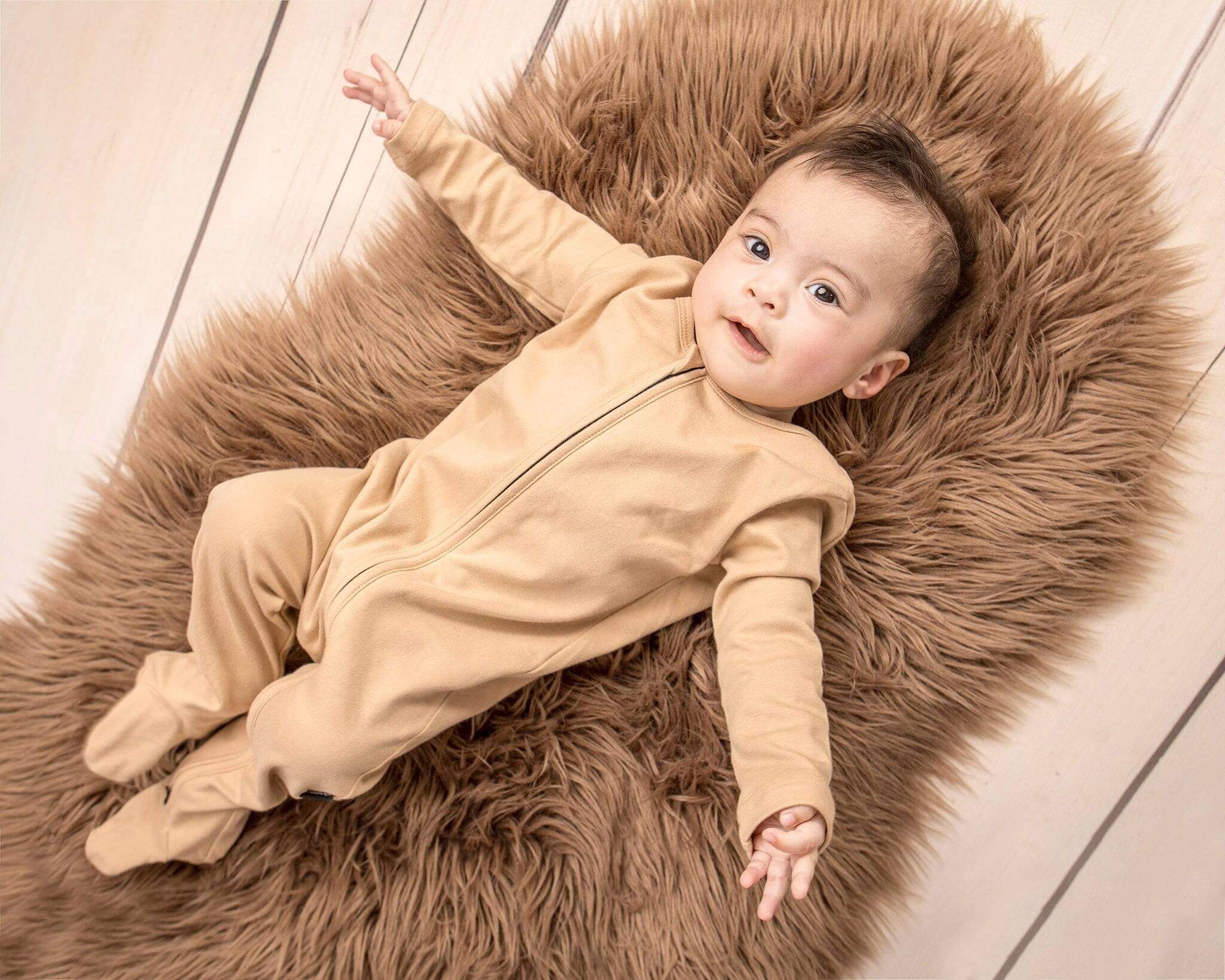 baby wearing khaki nueborn sleepsuit