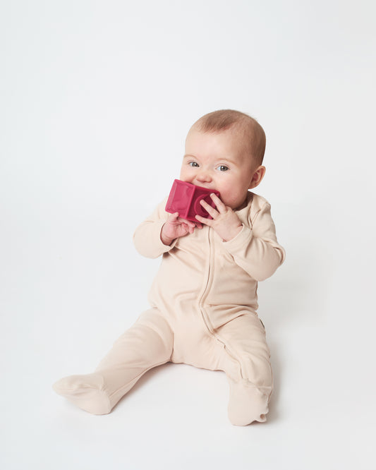 baby wearing the sandstone nueborn sleepsuit