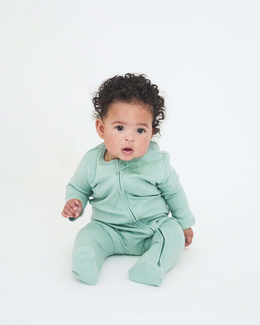 baby wearing the mint green nueborn sleepsuit