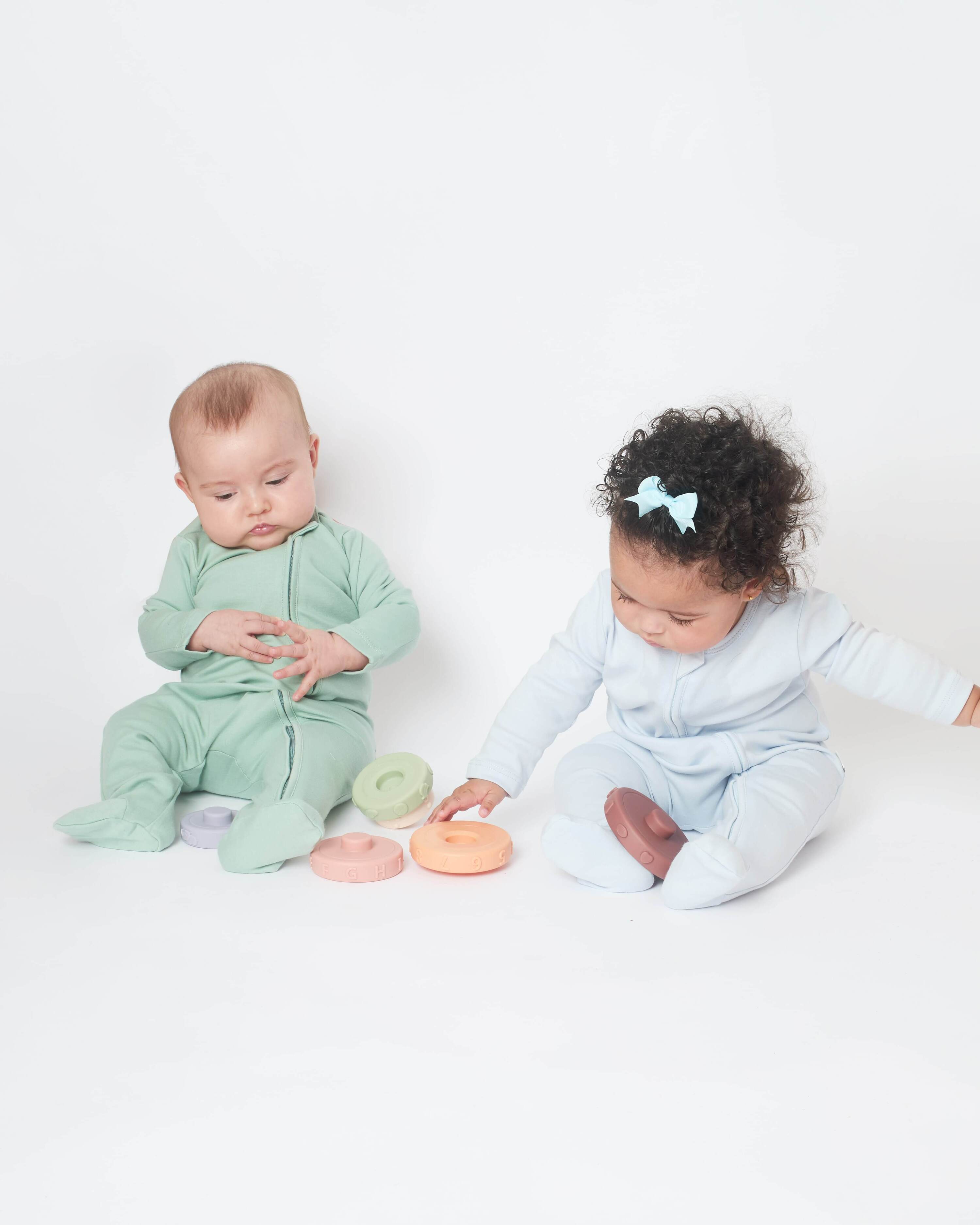 babies wearing mint green and sky blue nueborn sleepsuits