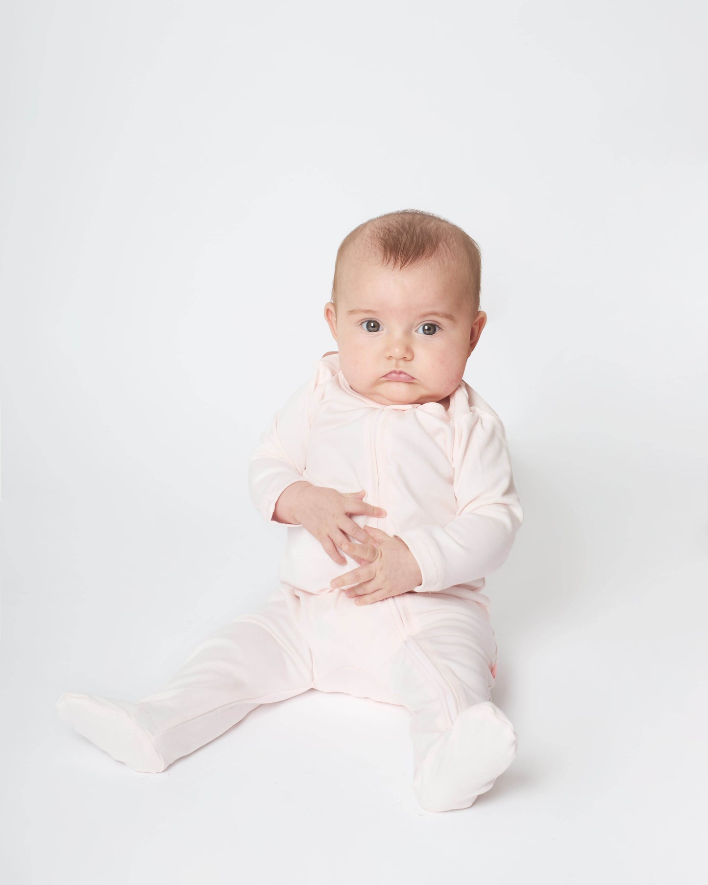 baby wearing the pink nueborn sleepsuit